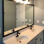 large mirror with black framing above bathroom vanity