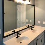 large mirror with black framing above bathroom vanity