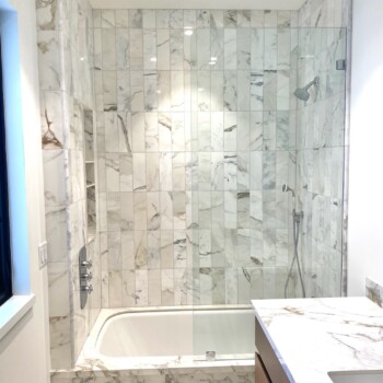 glass splash panel on marble tub