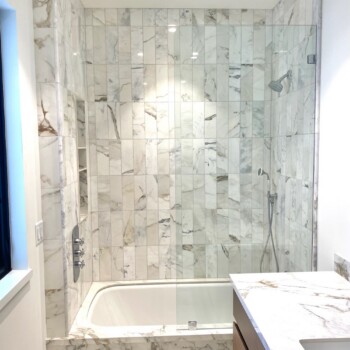 glass splash panel on marble tub